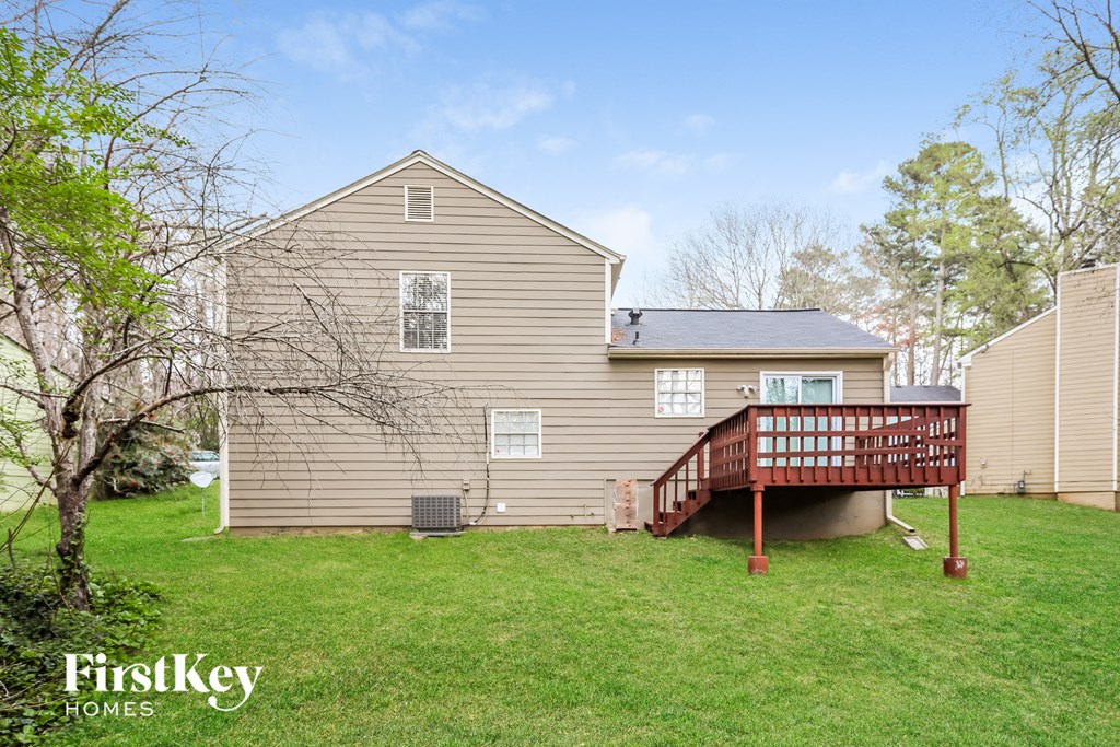 a backyard with a deck and a house with a red deck