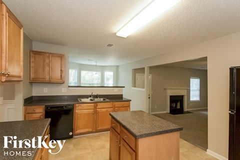 A kitchen with wooden cabinets and a black dishwasher.