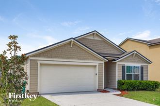 a beige house with a garage door and a lawn