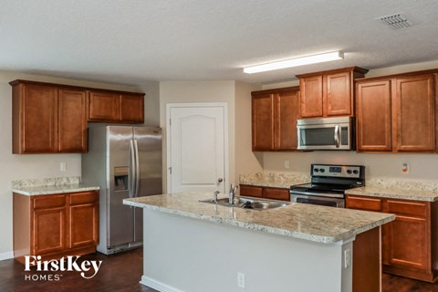 a kitchen with granite counter tops and wooden cabinets