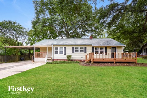 a small white house with a yard and a porch