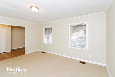 a living room with a rug and two windows