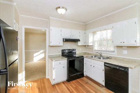 a kitchen with white cabinets and a black stove and refrigerator
