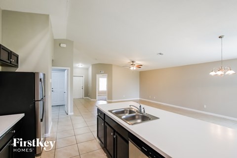 A kitchen with a sink and a refrigerator.