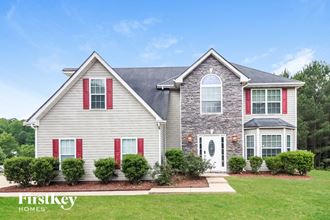 a house with white siding and red shutters and a lawn