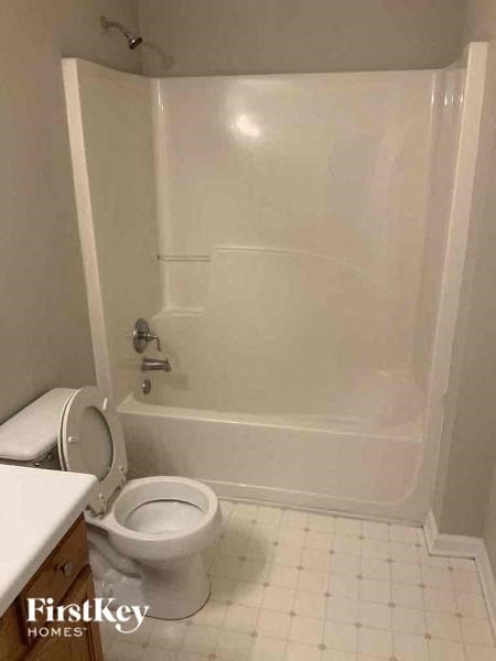 a white bathroom with a toilet and a tub