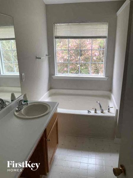 a bathroom with a tub and a sink and a window