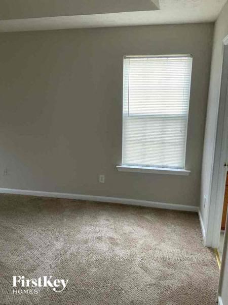 an empty room with a window and a carpeted floor