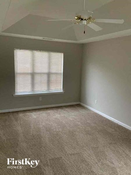 an empty room with a ceiling fan and a window