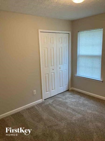 an empty room with a white door and a window
