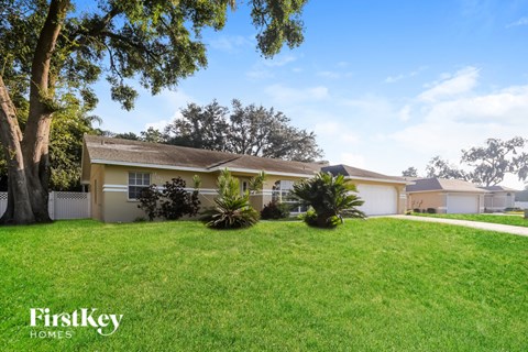 A house with a lawn and trees in front of it.