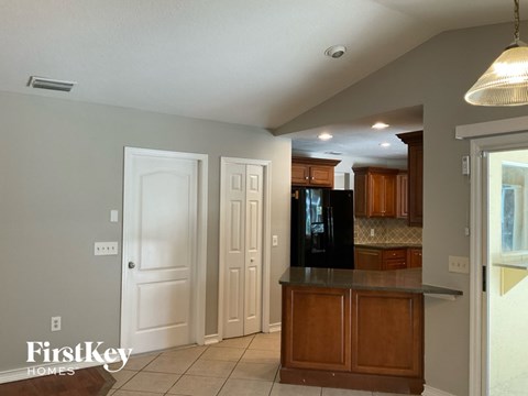 A kitchen with wooden cabinets and a black fridge.