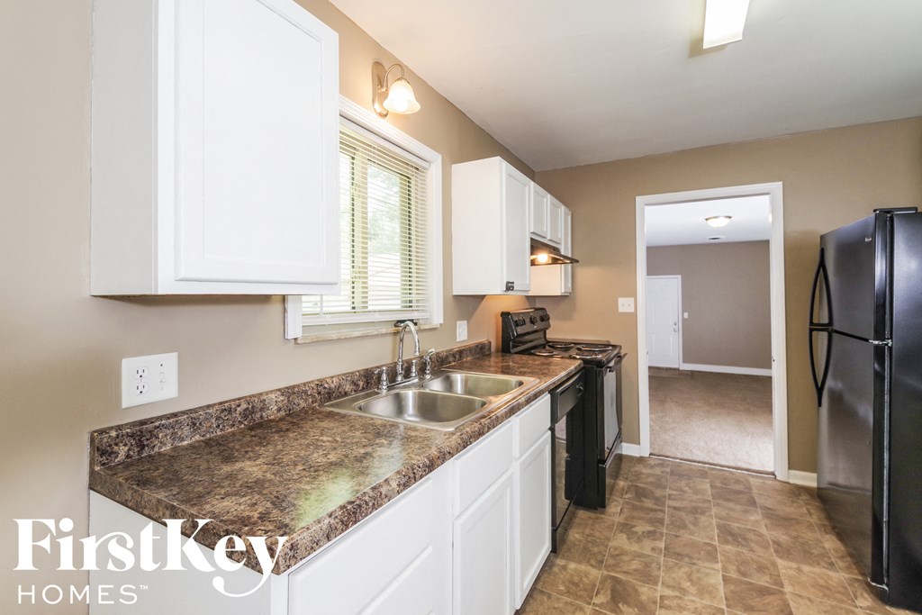 A kitchen with granite countertops and white cabinets.