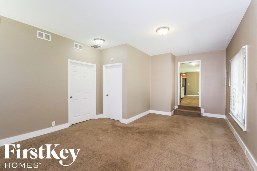 A room with a carpeted floor and a white door.