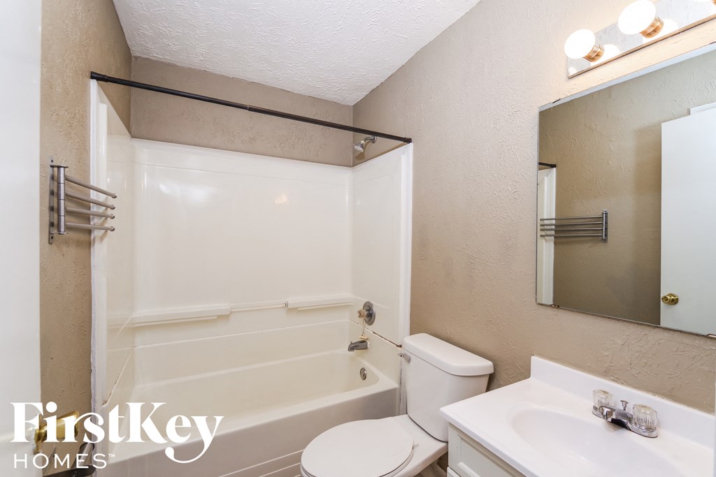 A bathroom with a toilet, sink, and bathtub.