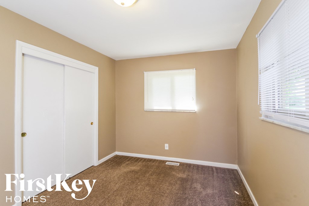 A room with a brown carpet and a white door.