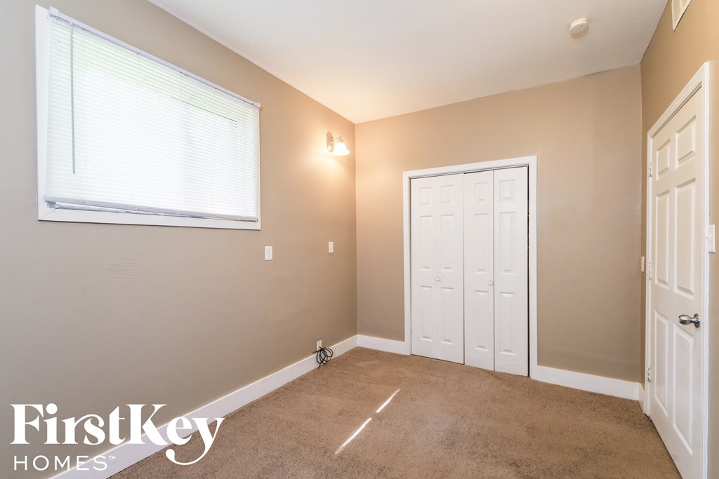 A room with a white door, a window, and a bicycle.