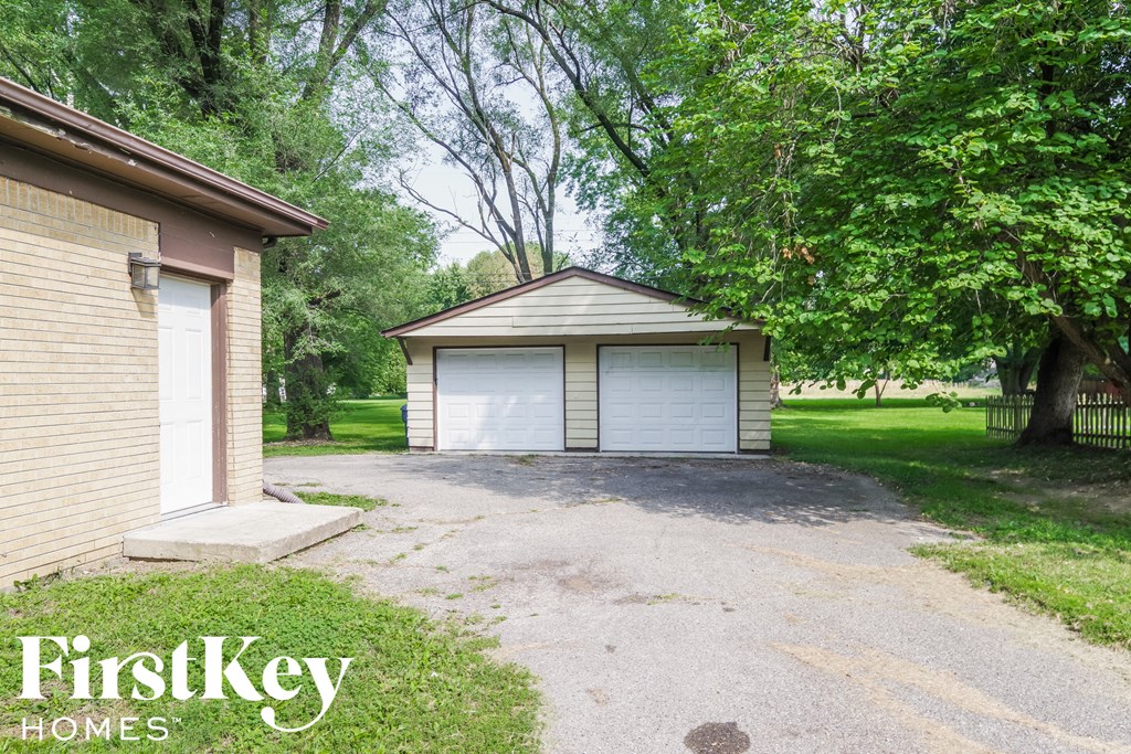 A garage with a white door is situated in a grassy area.
