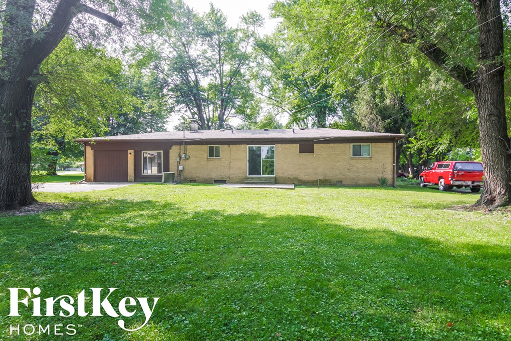 A house with a red car parked in front of it.