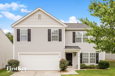 A two-story house with a garage and a driveway.