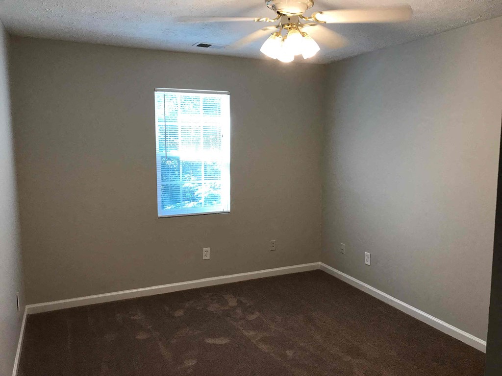 a empty room with a window and a ceiling fan