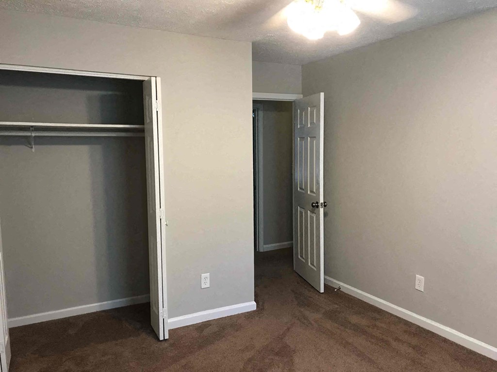 a bedroom with a closet and a door open to a closet