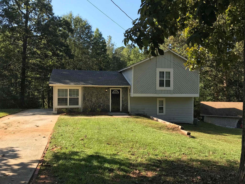 a white house with a driveway and a lawn