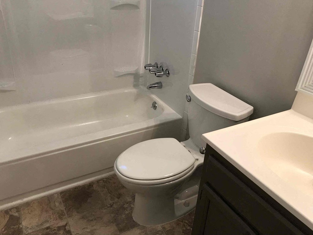 a bathroom with a toilet and a tub and a sink