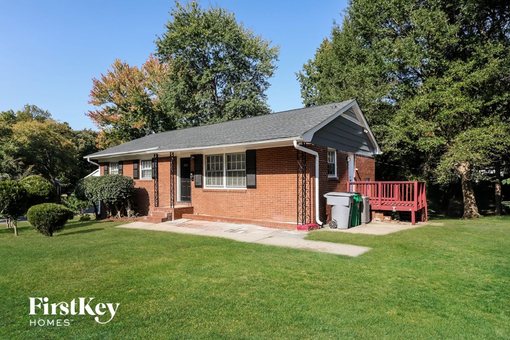 a small brick house with a porch and a red bench