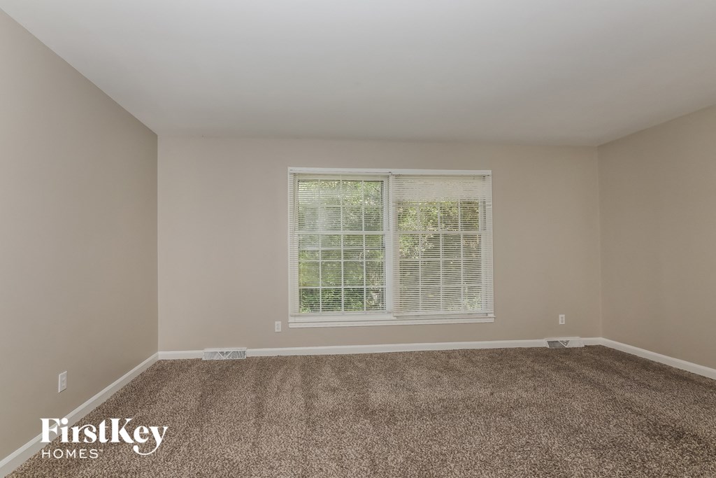 a empty room with carpet and a window