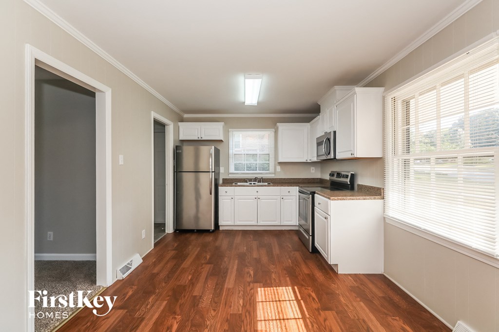 a renovated kitchen with white cabinets and stainless steel appliances