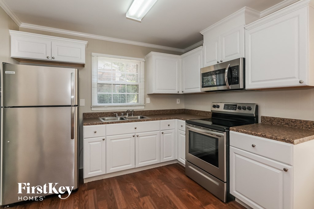 a kitchen with white cabinets and stainless steel appliances