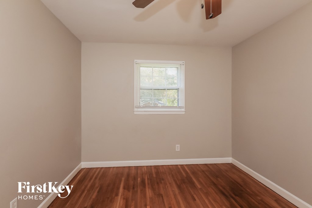 an empty room with wooden floors and a window