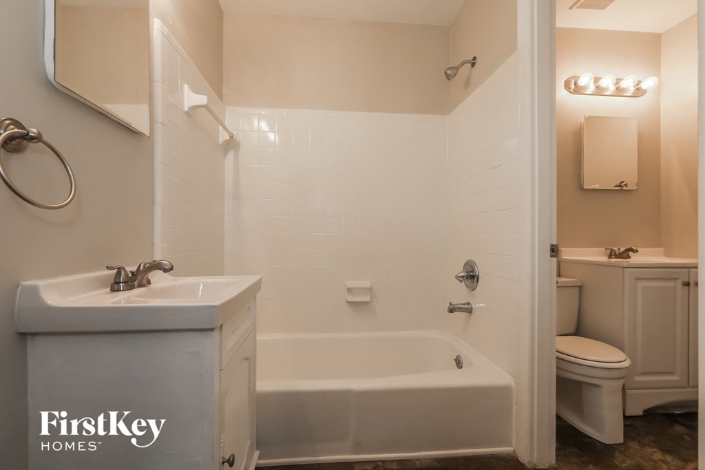 a white bathroom with a sink and a tub and a toilet