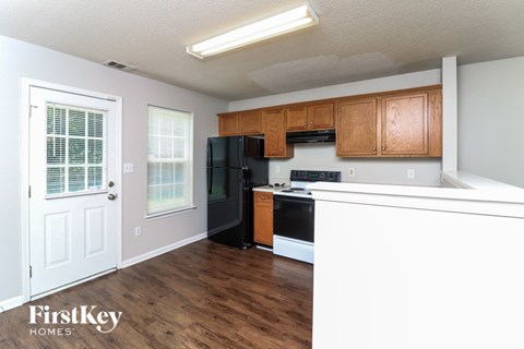A kitchen with wooden cabinets and black appliances.