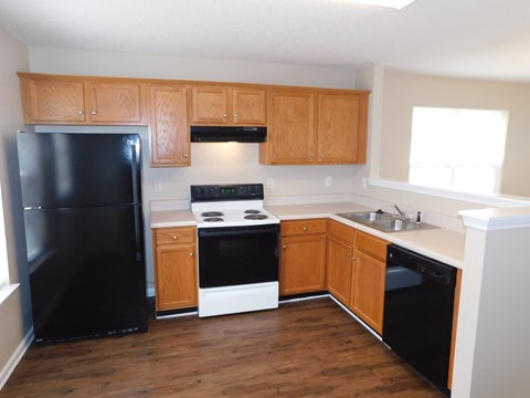 A kitchen with wooden cabinets and black appliances.