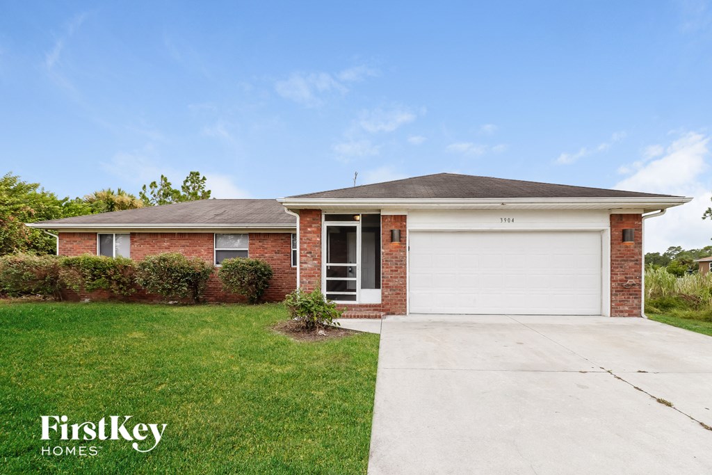 a small brick house with a white garage door