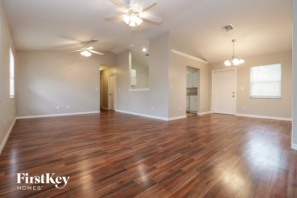 the living room and dining room with hardwood flooring and ceiling fans