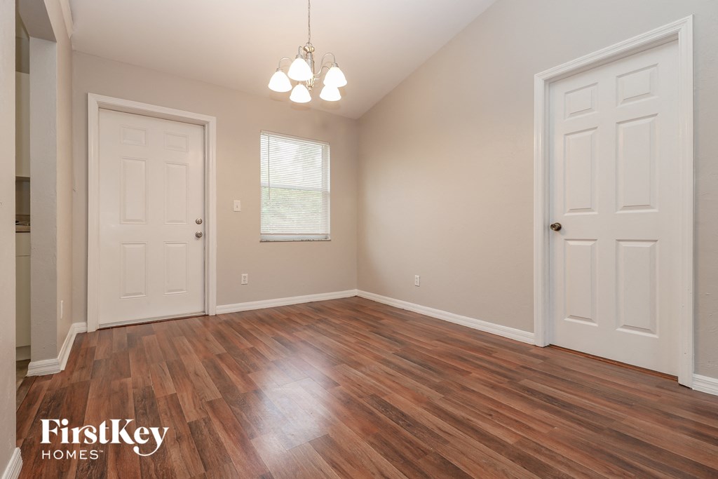 the living room of a home with a wood floor and white doors