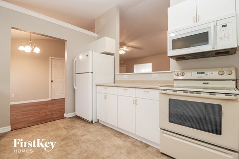 a kitchen with white appliances and a microwave and a refrigerator