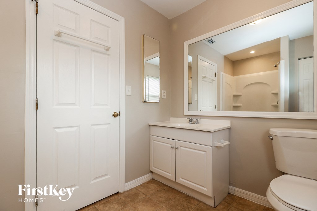 a bathroom with a toilet and a sink and a mirror