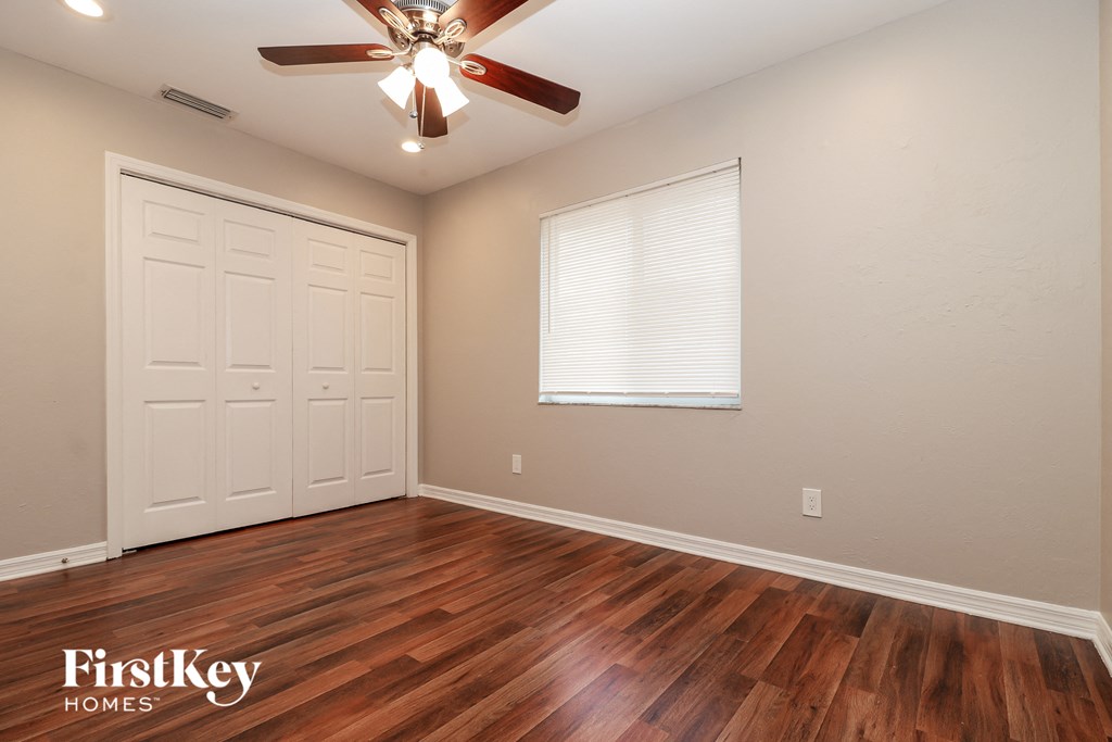 the living room of a home with wood floors and a ceiling fan