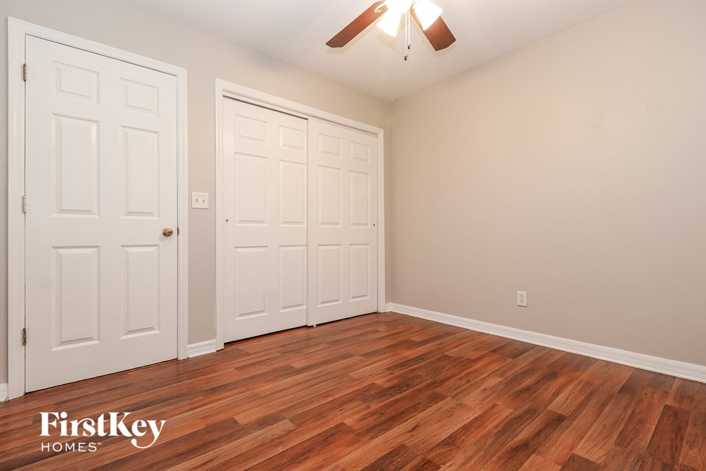 the living room of a home with a wood floor and two closets