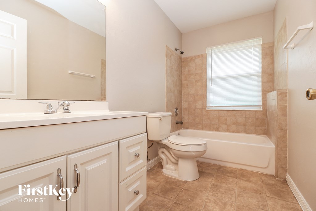 a bathroom with a toilet and a tub and a sink