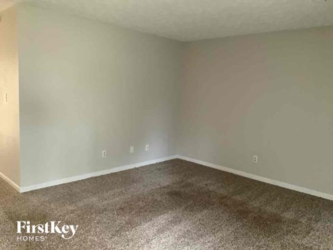 an empty living room with carpet and white walls