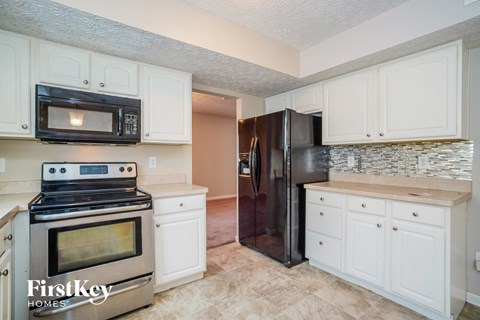 A kitchen with a stove, microwave, and refrigerator.
