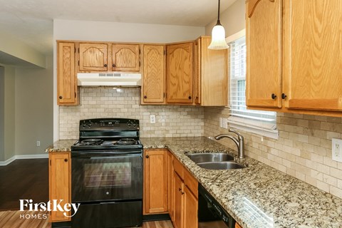 A kitchen with wooden cabinets and a black stove top oven.