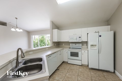 a kitchen with white appliances and a sink