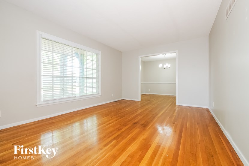 A room with wooden floors and a window with blinds.