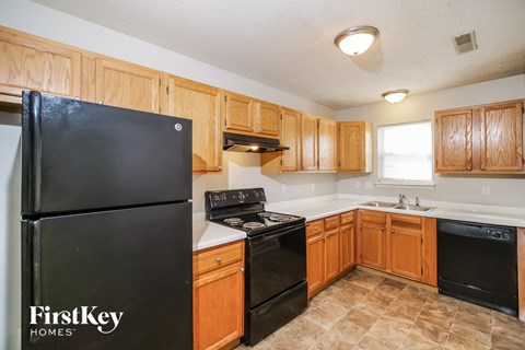 A kitchen with wooden cabinets and black appliances.